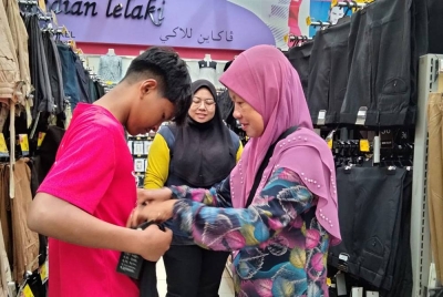 Zinorlaili (kanan) bersyukur kerana anaknya menerima bantuan persekolahan sebanyak RM100.