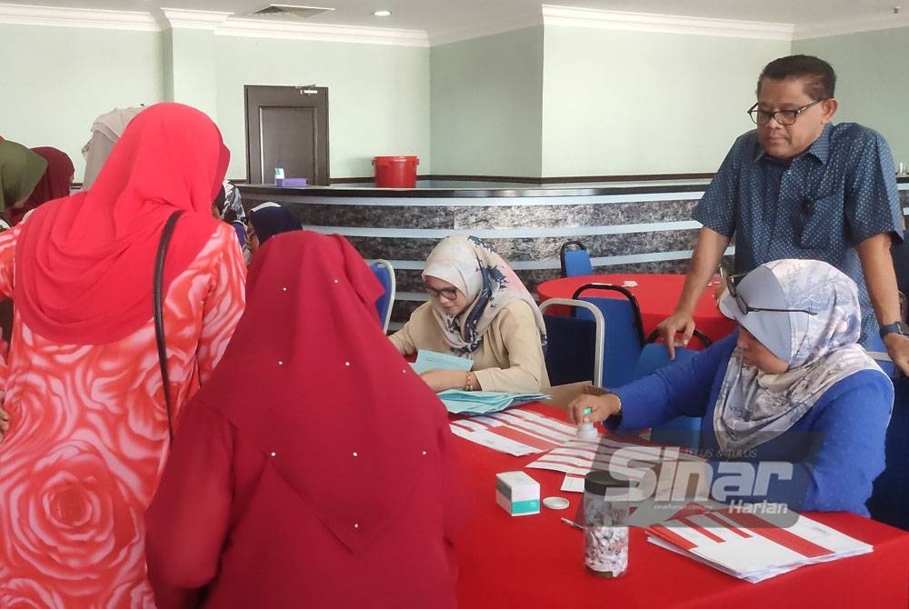 Setiausaha UMNO Kedah, Datuk Ariffin Man (kiri) meninjau sesi pendaftaran untuk proses pengundian semula Wanita UMNO Bahagian Kuala Kedah di Bangunan Tunku, di sini, pada Rabu.