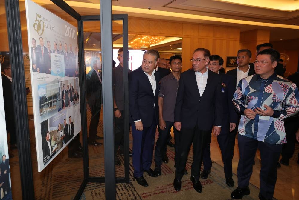 Anwar melihat ruang pameran ketika menghadiri Majlis Makan Malam Ulang Tahun Persatuan Pemaju Hartanah dan Perumahan Malaysia (REHDA) ke-50 di Petaling Jaya pada Rabu. - Foto Bernama