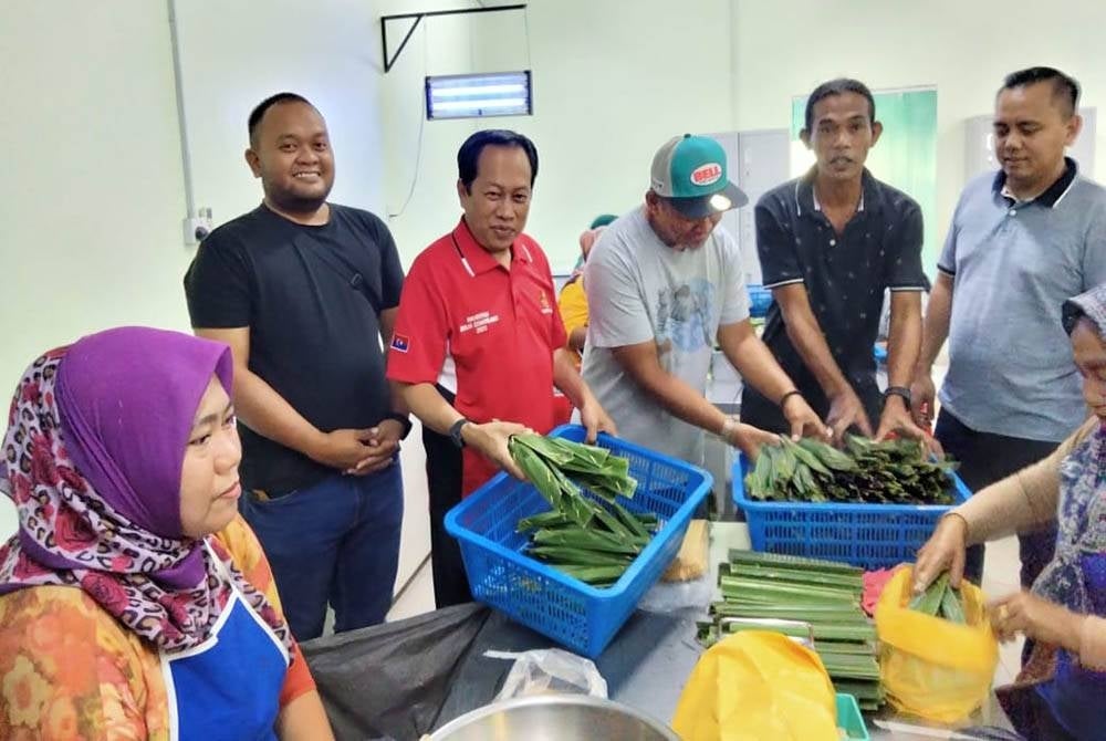 Ahmad (dua dari kiri) melawat perusahaan membuat otak-otak di Pontian Besar pada Jumaat.