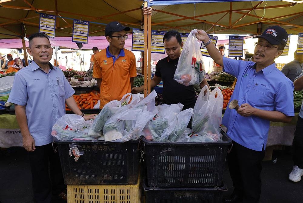Timbalan Ketua Pengarah (Pembangunan) FAMA Datuk Mohamad Mustahapa Awang (kanan) merasmikan Pelancaran Jualan Ramadan MADANI Peringkat Kebangsaan 2023 di Pasar Tani Putrajaya hari ini.