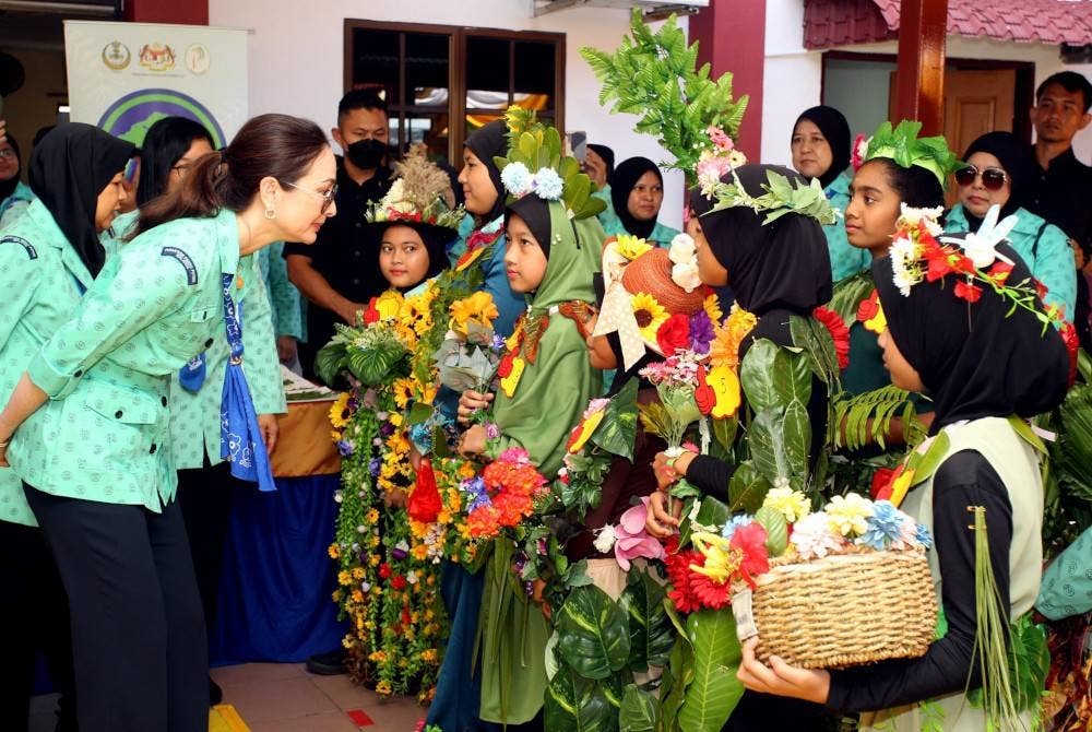 Tuanku Zara Salim (kiri) berkenan beramah mesra dengan Pasukan Pandu Puteri pada majlis Perasmian Program Penghijauan Malaysia Kempen Penanaman 100 Juta Pokok sempena sambutan 101 Tahun Pandu Puteri Perak di Pusat Latihan Perhutanan hari ini. - Foto Bernama