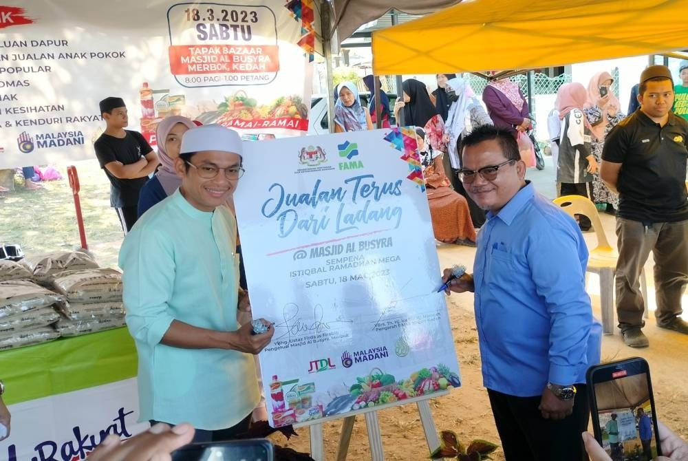 Isa (kanan) dan Mohd Firdaus menyempurnakan pelancaran Jualan Terus Dari Ladang sempena Istiqbal Ramadan Mega @Masjid Al-Busyra pada Sabtu.