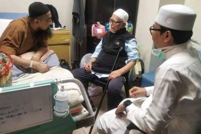 Abdul Hadi (tengah) bersama Muhammad Khalil meluangkan masa menziarahi Ustaz Azhar yang dimasukkan ke Hospital Sultanah Nur Zahirah (HSNZ) di Kuala Terengganu sejak Selasa lalu. - Foto: FC Muhammad Khalil