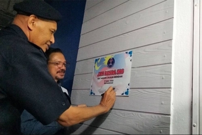 Mit (kiri) disaksikan Abd Hadi menandatangani plak Pusat Rukun Tetangga KRT Mukim Dusun Rendah bagi merasmikan Program Gerak Rahmah 2023 Jom Ronda SRS Peringkat Negeri Kelantan malam Sabtu.