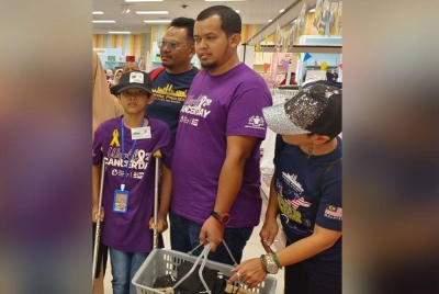 Muhammad Durrani (kiri) ketika membeli peralatan sekolah bersama ibu bapanya dalam Program Kembali ke Sekolah Empire di Aeon Mall, Kulai pada Sabtu.