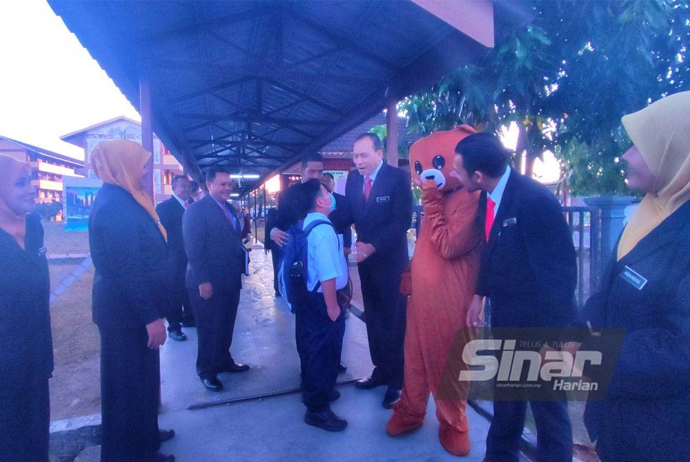 Pengarah Pendidikan Kedah, Rozaini Ahmad (empat kanan) beramah mesra dengan murid sempena hari pertama persekolahan sesi 2023/2024 di Sekolah Kebangsaan (SK) Taman Uda, di sini, pada Ahad.