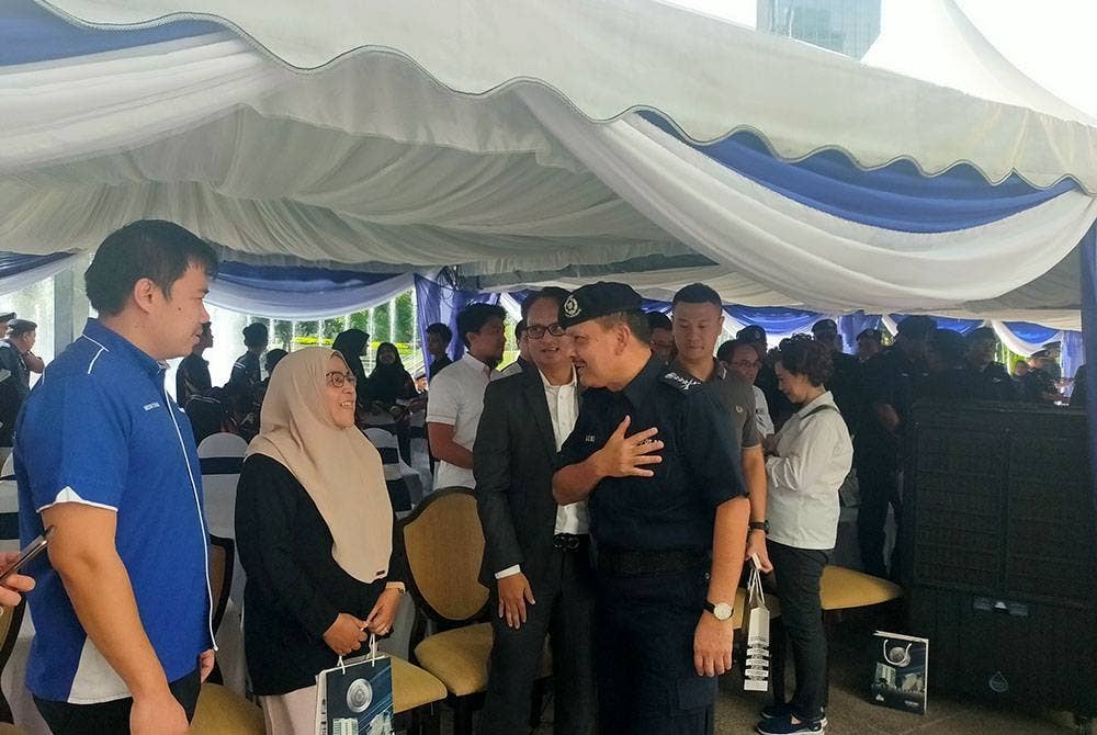 Azmi (kanan) meluangkan masa beramah mesra dengan orang ramai dalam Program High Profile Policing bersama Ketua Polis Kuala Lumpur, sempena Peringatan Hari Polis Ke-216 Tahun 2023 di Esplanade Kuala Lumpur Convention Centre, di Kuala Lumpur pada Ahad.