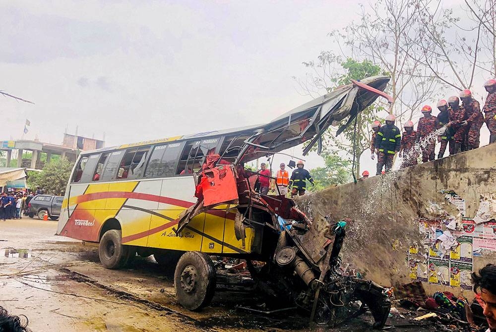 Les pompiers éteignent l'incendie d'un bus qui a plongé dans un fossé au Bangladesh.  -AFP