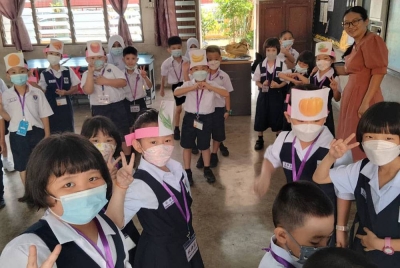 Kim Li (kanan) bersama muridnya yang memulakan persekolahan sesi 2023/2024 Sekolah Jenis Kebangsaan (C) Chung Hwa pada Ahad.