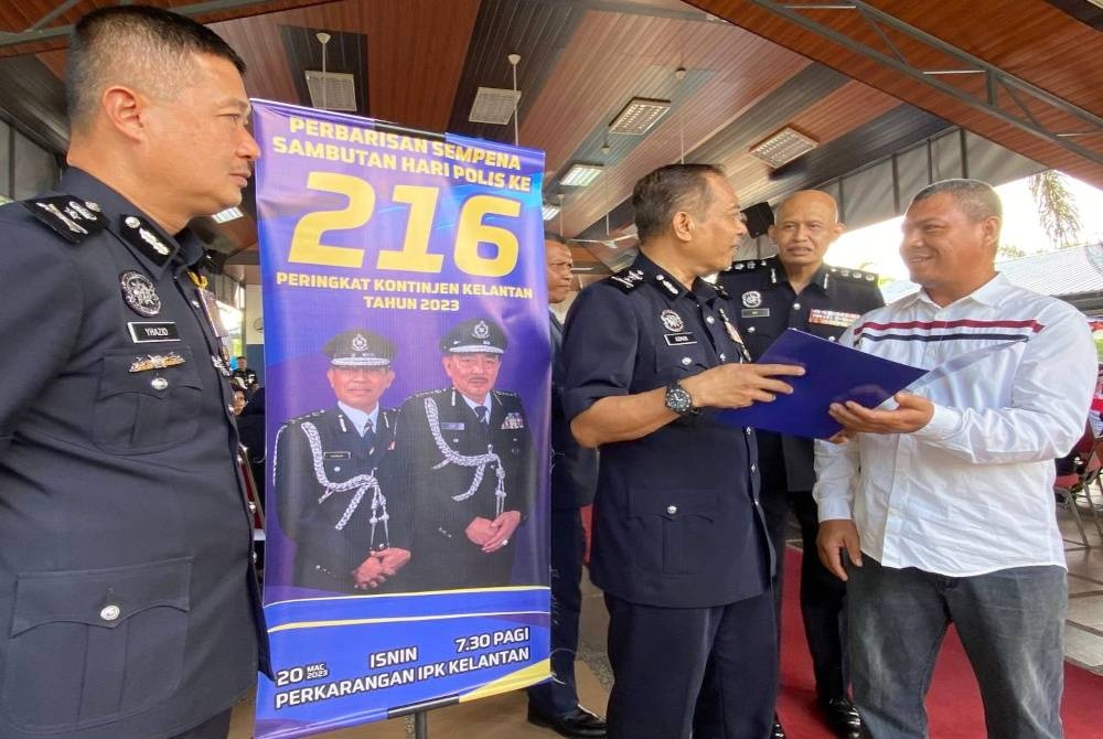 Abdul Ghani (kanan) menerima sijil penghargaan daripada Azman (dua dari kiri) ketika Sambutan Hari Polis ke-216 di Kota Bharu pada Isnin.