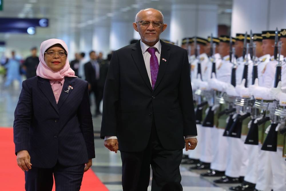 Halimah (kiri) bersama suami Mohamed Abdullah Alhabsee melintasi kawalan kehormat setempat oleh Batalion Pertama Rejimen Renjer Diraja (Istiadat) sejurus tiba di KLIA untuk memulakan lawatan negara ke Malaysia mulai hari ini hingga 22 Mac. - Foto Bernama