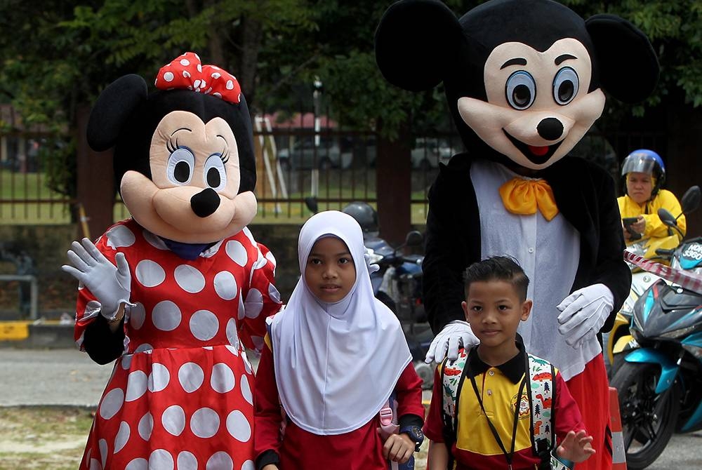 Murid-murid mesra disambut maskot Mickey dan Minnie Mouse ketika hadir pada hari pertama sesi persekolahan 2023/2024 di Sekolah Kebangsaan Tasik Damai hari ini.