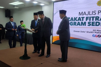 Norizan (tengah) melakukan gimik pelancaran pada Majlis Pelancaran Zakat Fitrah Online dan Program Sedekah Foodbank di Menara Zakat pada Isnin.
