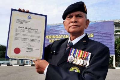 Mohamad Noh menunjukkan sijil penghargaan yang diterima.