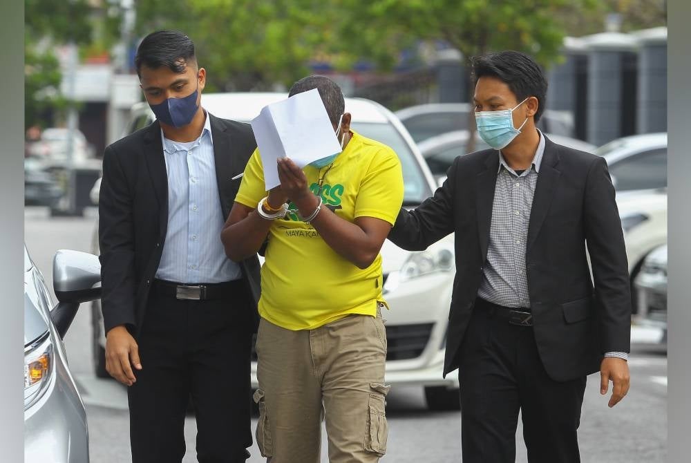 Tertuduh diiring pegawai SPRM ketika tiba di mahkamah pada Selasa.