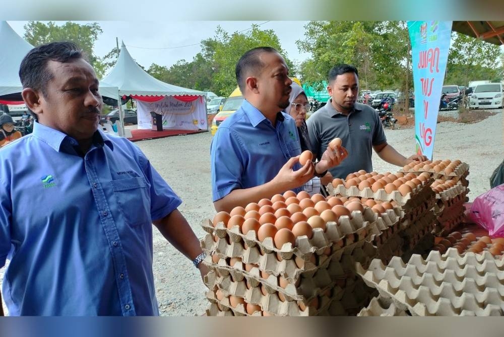 Hairudin (dua dari kiri) melihat jualan telur gred C FAMA Melaka dengan harga RM10 sepapan pada Program Jualan Pra-Ramadan Melaka Madani 2023 di Bukit Katil pada Selasa.