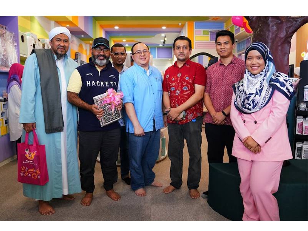 Dahlia (kanan) bersama para tetamu semasa majlis pelancaran butik Izzlyku.