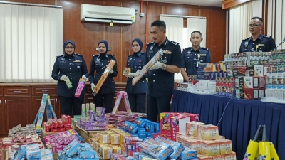 Yusharifuddin (tiga dari kanan) menunjukkan mercun dan bunga api dirampas dalam serbuan dilakukan sepasukan anggota dari Bahagian Siasatan Jenayah IPD Kangar.