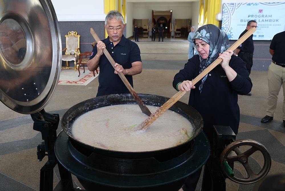 Al-Sultan Abdullah dan Tunku Azizah berkenan menyediakan juadah bubur lambuk Pahang, untuk diedar kepada orang ramai sempena Program Memasak Bubur Lambuk Istana Negara di Istana Negara pada Jumaat. - Foto Bernama