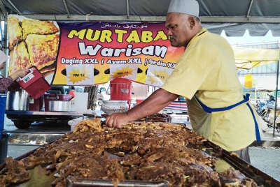 Saidi menyiapkan martabak ayam dan daging di pasar Ramadan Perkampungan Sungai Isap disini.