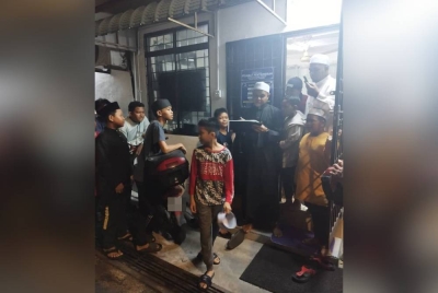 Yuskamarul (berjubah hitam) mengambil kedatangan kanak-kanak yang hadir ke Masjid At Taqwa untuk solat tarawih bagi menyertai Program Kasih Anak-Anak Ramadan.