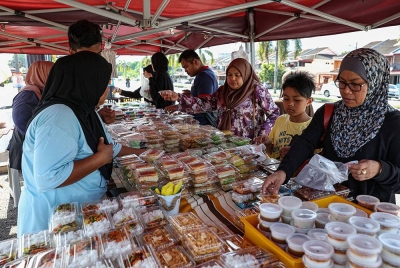 Pelanggan membeli pelbagai kuih muih yang dijual pada harga RM1 sepaket di sebuah gerai di Taman Klebang Restu, semalam.