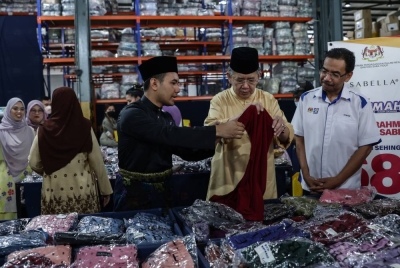 Salahuddin (dua dari kanan) melihat produk pakaian Sabella selepas Pelancaran Jualan Rahmah Hari Raya bersama jenama pakaian Sabella di Pejabat Sabella hari ini. - Foto Bernama