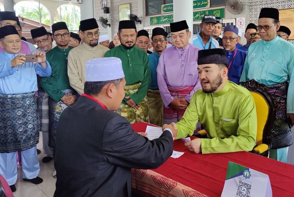 Raja Muda Selangor, Tengku Amir Shah sambil diperhatikan Mazlan (berdiri depan dua kanan) menunaikan infak pada Majlis Penyampaian Sumbangan YIDE kepada anak yatim di Masjid Kampung Sungai Terap pada Ahad.
