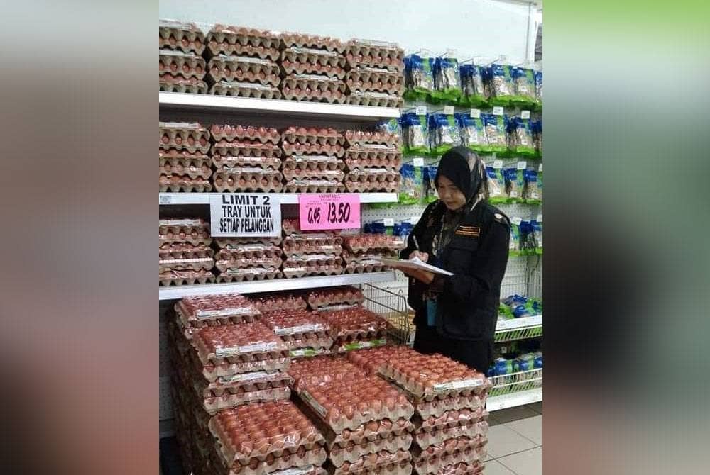 Anggota KPDN melakukan pemeriksaan bekalan telur ayam di pasaraya pada Ahad. - Foto: KPDN