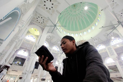 Penduduk Kuantan Faiz Ahmad tekun membaca Al-Quran di Masjid Negeri Sultan Ahmad Satu hari ini.