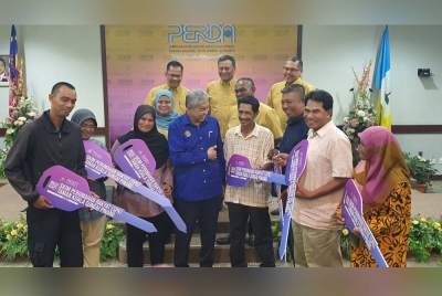Ahmad Zahid (tengah) bergambar bersama penerima kunci Skim Perumahan Rakyat Perda pada Ahad.