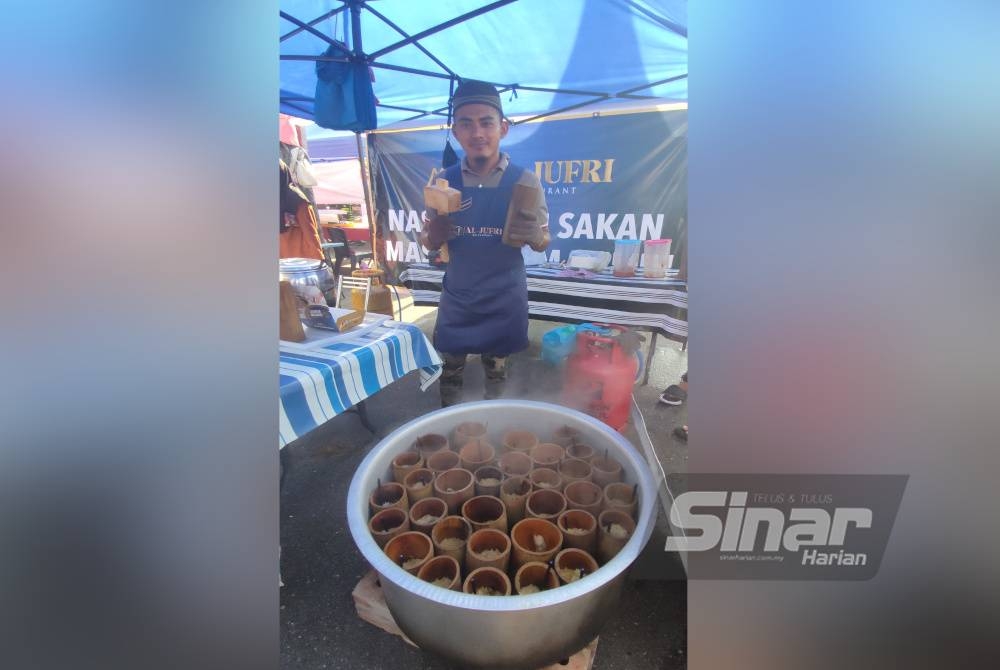 Mohd Afif menunjukkan nasi beriani buluh yang dijual di gerainya di Bazar Ramadan Jalan Stadium, Alor Setar.