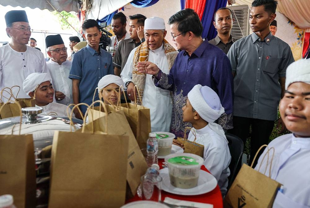 Ahmad Zahid (empat dari kanan) bersama Ketua Menteri Pulau Pinang, Chow Kon Yeow berbual bersama pelajar tahfiz pada Majlis Santunan Kasih Ramadhan di Masjid Jamek Al-Islah pada Ahad. - Foto: Bernama