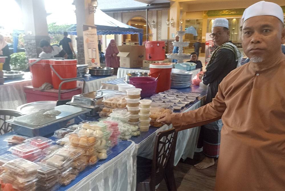 Mohamad Sapar menunjukkan juadah berbuka puasa yang disediakan secara percuma di Masjid Al Asma'ul Husna Bandar Uda Utama.
