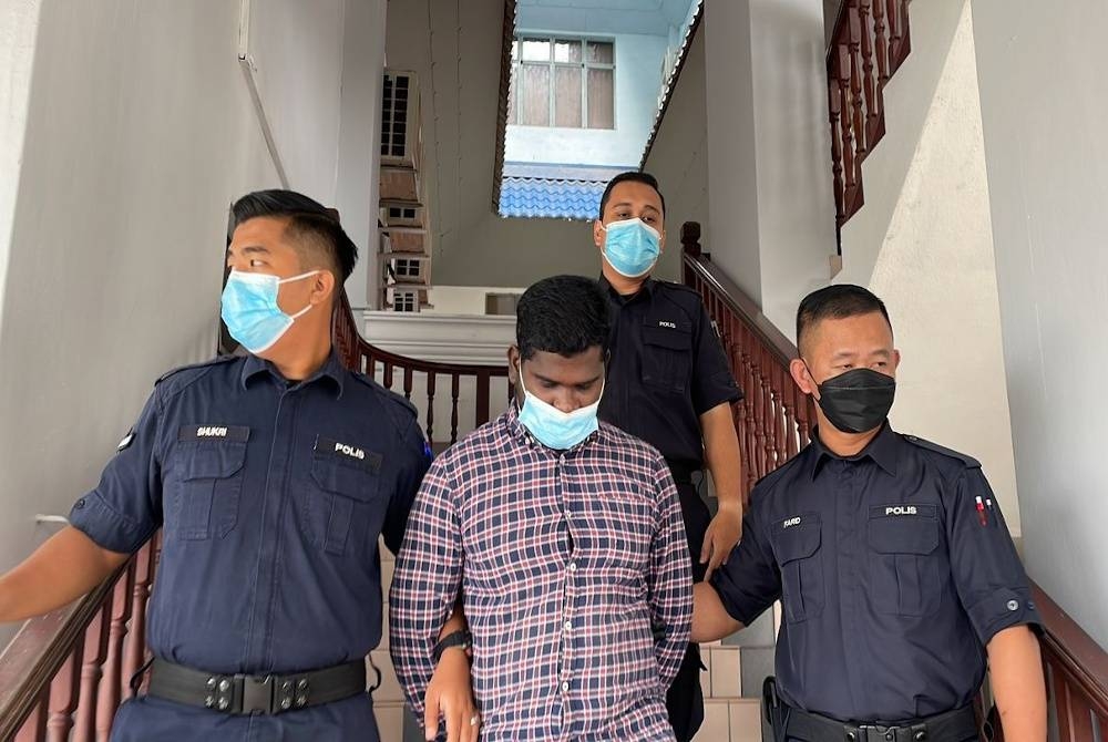 Logamurugan (dua dari kiri) ketika dibawa keluar dari Mahkamah Majistret di Ayer Keroh pada Isnin.