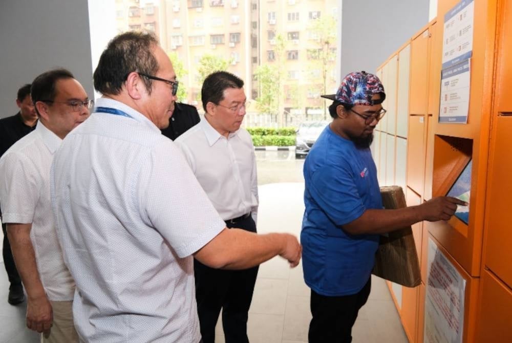 Kor Ming melihat penghantaran bungkusan di lokar bungkusan pintar di SkyAwani 3 Residences.