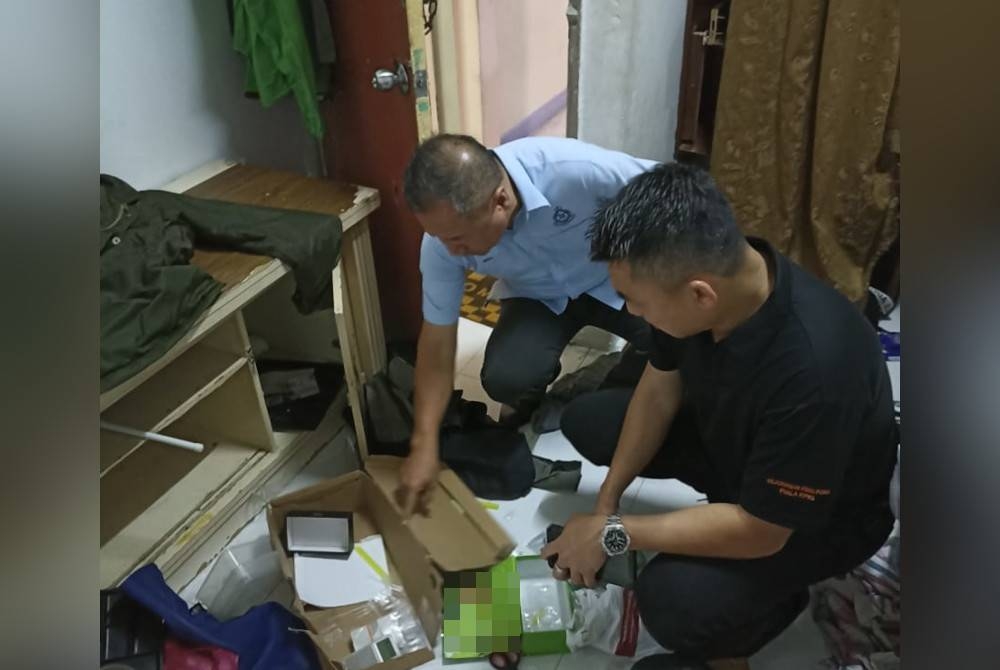 Eng Lai (kiri) sedang memeriksa unit kediaman yang diserbu di sebuah flat di Jinjang, Kuala Lumpur pada Isnin.