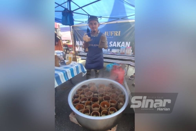 Mohd Afif menunjukkan nasi beriani buluh yang dijual di gerainya di Bazar Ramadan Jalan Stadium, Alor Setar.