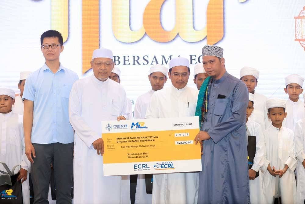 Ahmad (dua dari kiri) dan diiringi Darwis (dua dari kanan) menyampaikan sumbangan kepada Mohd Noor.