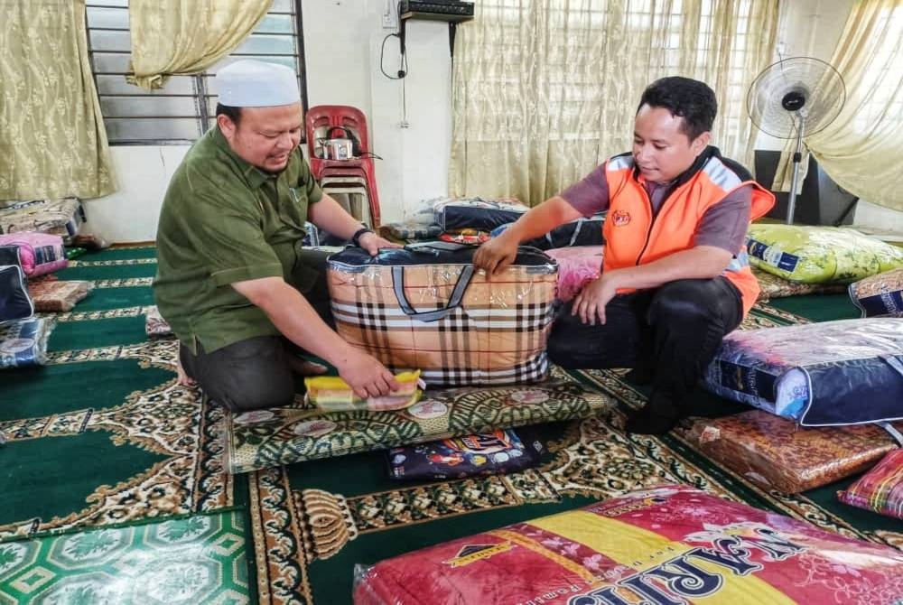 Mohd Azam melihat barang keperluan yang disumbangkan Jabatan Kebajikan Masyarakat (JKM) di surau Kampung Tualang di sini.