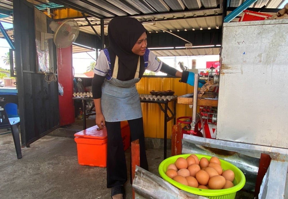 Nurul Atikah menyiapkan tempahan walaupun bekalan telur ayam berkurangan, namun masih dapat berniaga seperti biasa