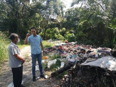 Hian Wah (kanan) meninjau lokasi pembuangan sampah haram di Putra Permai.