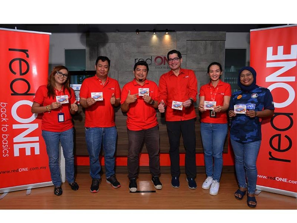 Farid (tiga dari kanan) bersama kakitangan redONE menunjukkan salah satu pelan yang ditawarkan oleh syarikat itu.
