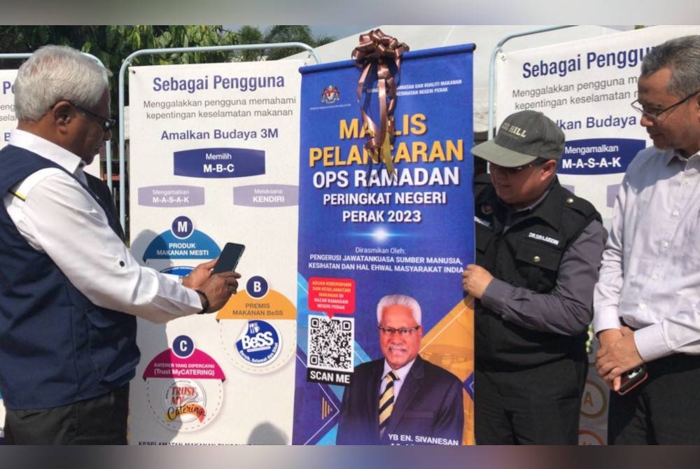 Sivanesan (kiri) mengimbas kod QR yang disediakan pada Pelancaran Operasi Ramadan peringkat negeri Perak di Tapah.