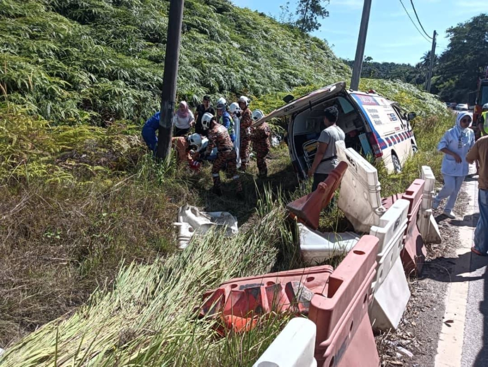 Anggota bomba membantu mengeluarkan mangsa yang tersepit. - Foto ihsan polis