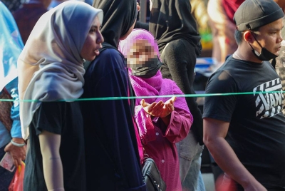 Pengemis warga asing menjalankan aktiviti meminta wang sedekah daripada pengunjung yang datang ke Bazar Ramadan. Foto Bernama.