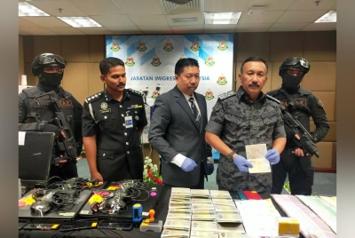 Ruslin (kanan) menunjukkan pasport yang dirampas dalam operasi sindiket perjudian didalangi warga asing di sekitar Selangor dan Kuala Lumpur.