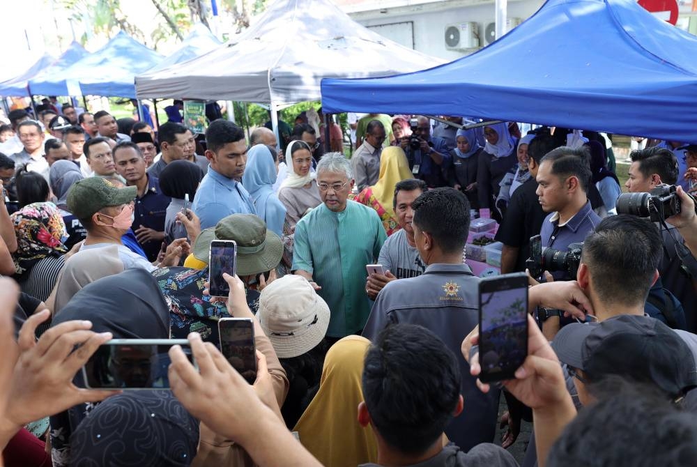 Al-Sultan Abdullah dan Tunku Hajah Azizah Aminah Maimunah Iskandariah berkenan beramah mesra bersama orang ramai ketika melawat ke Bazar Ramadan Labuan Walk sempena lawatan dua hari Baginda ke Labuan bermula pada Jumaat. - Foto Bernama