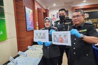 Sharifah Sitti Saleha (kiri) menunjukkan gambar suspek yang ditahan dalam Operasi Bersepadu Serkap di Kota Kinabalu.